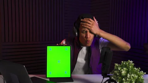Multi-ethnic man watches in tablet and reacts emotionally. Green screen on tab. Video stock 147100489
