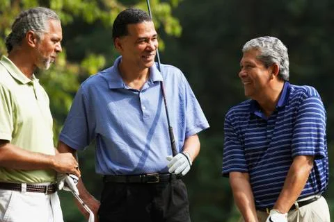 Multi-ethnic men holding golf clubs Stock Photos
