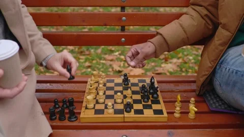 Multi-ethnic men playing chess in autumn park on a bench. Close-up. Stock Footage 271325508