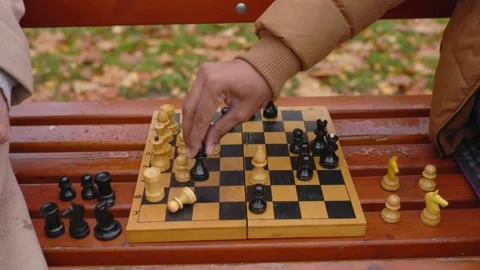 Multi-ethnic men playing chess in autumn park on a bench. Close-up. Stock Footage 271325527