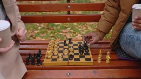 Multi-ethnic men playing chess in autumn park on a bench. Close-up. Stock Footage 271325565