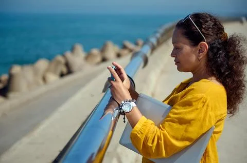 Multi ethnic middle aged pretty woman using smart mobile phone, photographing 스톡 사진