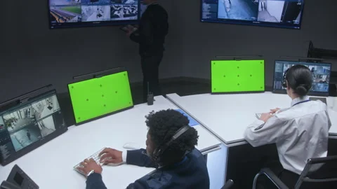 Multi ethnic officers and operators control CCTV cameras Stock Footage 240473911