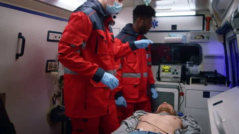 Multi ethnic paramedics giving first aid help to man in emergency car Stock Footage 166866050
