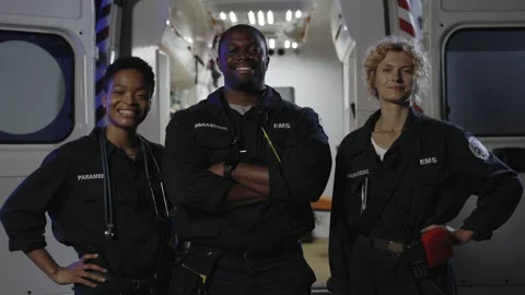 Multi ethnic paramedics smiling on camera near ambulance Stock Footage 164167538