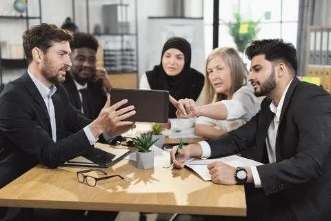 Multi ethnic partners using tablet during meeting at office 스톡 사진