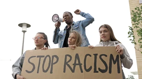 Multi-ethnic people protesting for equal rights hold poster Stop racism. Dark Stock-Footage 134153520