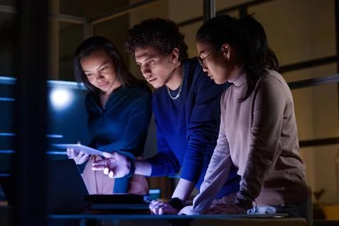 Multi-ethnic Programmers Working At Night Stock-Fotos