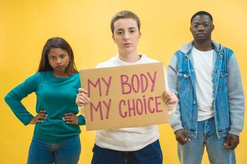 Multi ethnic students holding banner showing message abortion. Isolated on Stock Photos