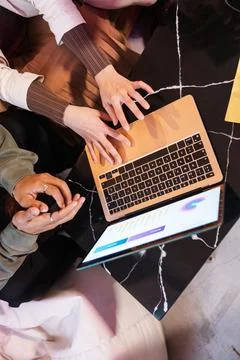 Multi ethnic team analyzing charts on laptop, coworkers discussing data in 写真素材