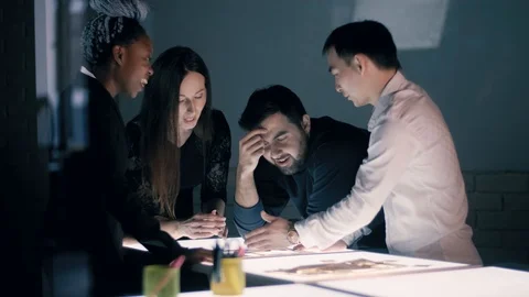 Multi-ethnic team of architects engineers works at night on a new creative Stock Footage 124943287