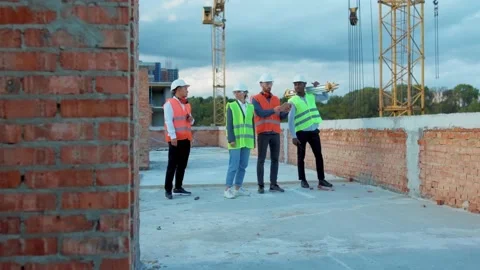 Multi ethnic team engineers taking stand construction at sunlight survey urban Stock Footage 139340969
