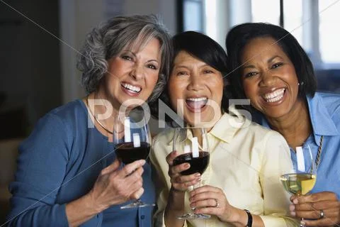Multi-ethnic women drinking wine Stock Photos