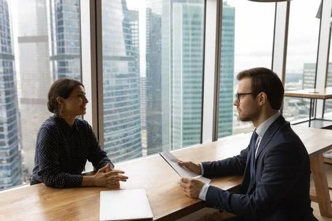 Multi ethnic young businesspeople negotiating in modern office Stock Photos