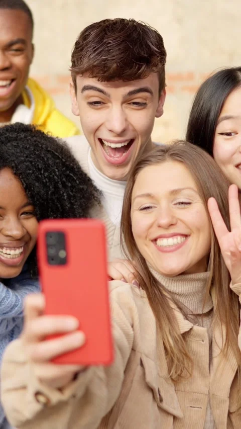 Multi-ethnic young friends celebrating while taking a selfie outdoors Stock Footage 265755365