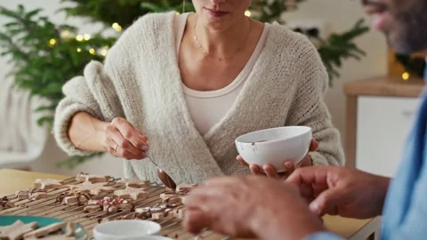 Multi ethnicity couple decorating sweet cookies at home during the Christmas Stock Footage 218776027