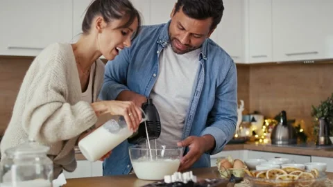 Multi ethnicity couple making a cake together in Christmas time Stock Footage 218783804