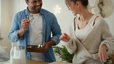 Multi ethnicity couple making a gingerbreads in Christmas time Stock Footage 218748363