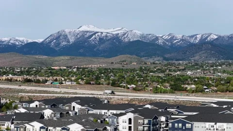 Multi-family apartment complex spreads along busy desert highway, where rows of Stock Footage 338185676