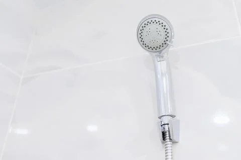 Multi-function chrome-plated shower head with hose in the bathroom. Copy space. Stock Photos