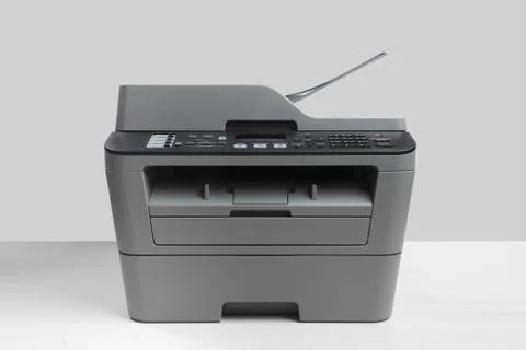 A multi function printer, copier, scanner on office table. gray wall behind Foto stock