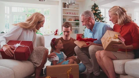 Family Opening Christmas Presents At Home Together Stock Photo