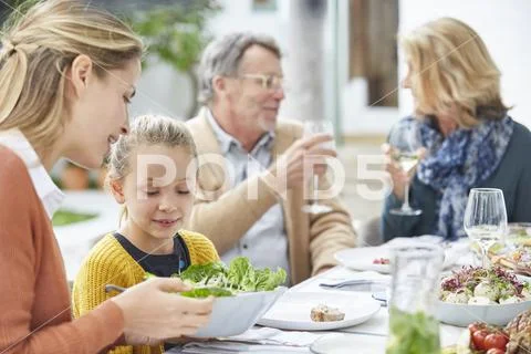 Multi-generation family enjoying lunch on patio Stock Photos