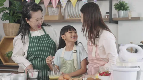 Multi-generation family preparing a bread/cake at home Stock Footage 255477953