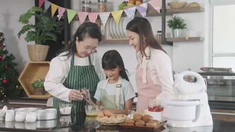 Multi-generation family preparing a bread/cake at home Stock Footage 255478041