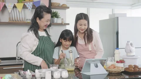 Multi-generation family preparing a bread/cake at home Stock Footage 255478100