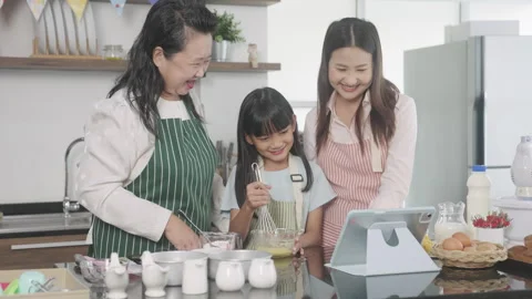 Multi-generation family preparing a bread/cake at home Stock Footage 255478326