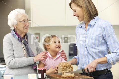 Multi-generation family preparing food in kitchen Stock Photos