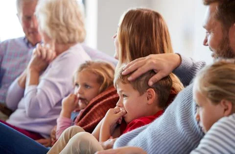 Multi-Generation Family Relaxing At Home Sitting On Sofa Watching Television Stock Photos
