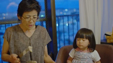 Multi-generation family serving and eating food at home. Stock Footage 100831830