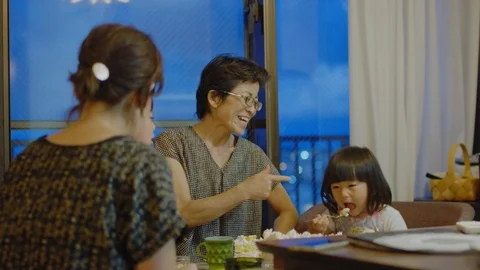 Multi-generation family serving and eating food at home. Stock Footage 100833454