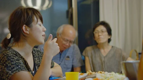 Multi-generation family serving and eating food at home. Stock Footage 100840483