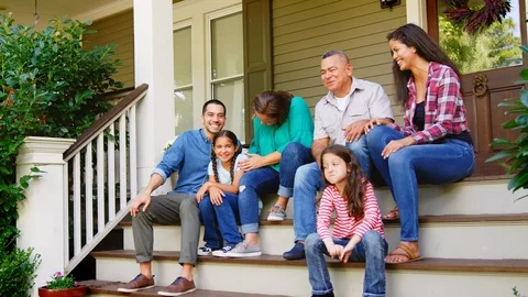 Multi Generation Family Sit On Steps Leading Up To House Porch Stock Footage