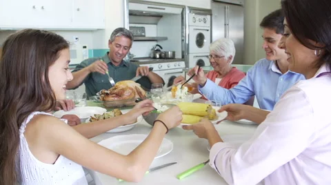 Multi-Generation Family Sitting Around Table Eating Meal Stock Footage