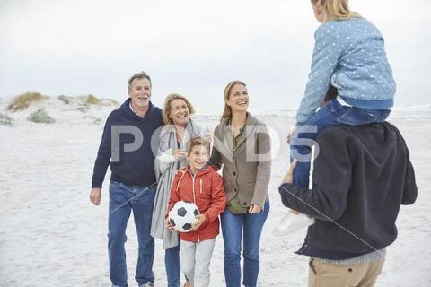 Multi-generation family with soccer ball on winter beach Stock Photos