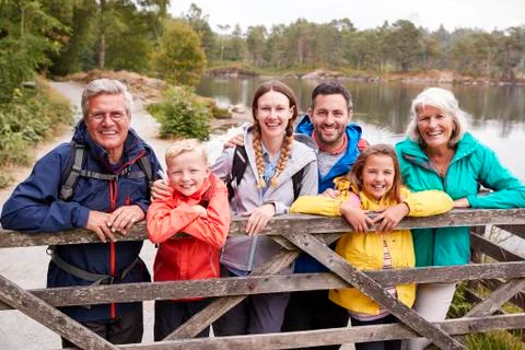 Multi generation family standing behind a wooden fence looking to camera, Lak Stock Photos