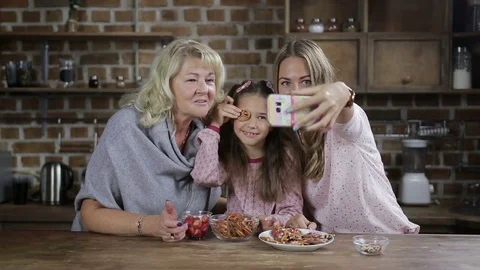 Multi generation family taking pictures in kitchen Stock Footage
