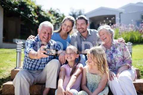 Multi-Generation Family Taking A Selfie In The Garden