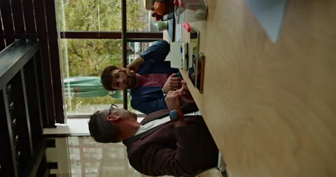 Multi generational business coworkers collaborating on strategic planning and Stock Footage 273494273