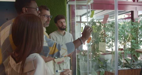 Multi generational business team writing new ideas on sticky notes over the Stock Footage 273813662