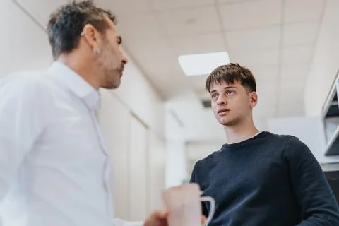 Multi generational colleagues discuss project development while taking a break 스톡 사진