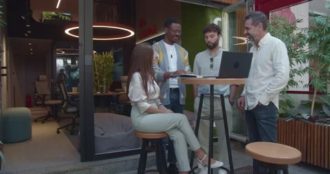 Multi generational, creative, business teammates gathered at table collaborating Stock Footage 268650591