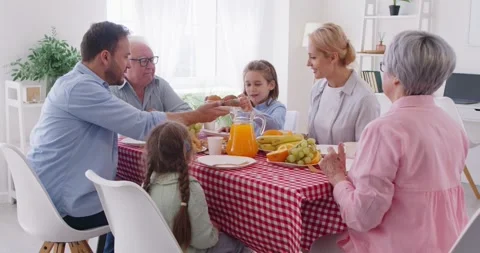 Multi generational family sits at table enjoying bright atmosphere of breakfast. Stock Footage 317052856