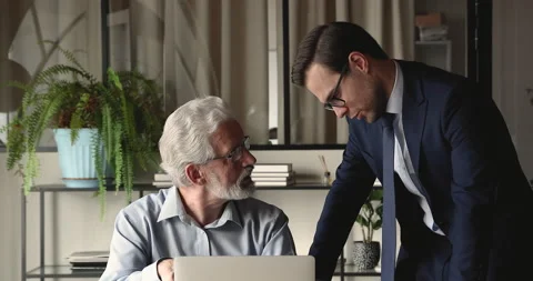 Multi generational workmates use laptop discuss online project Stock Footage 158051968