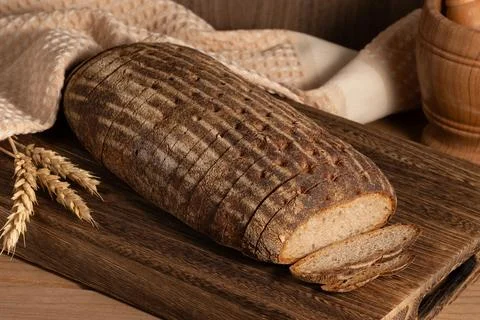 Multi grain sourdough bread with flax seeds cut on a wooden board, closeup Stock Photos