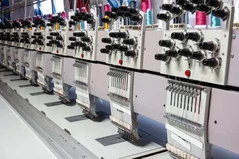 Multi head industrial sewing machine close up view inside small out of busine Stock-Fotos